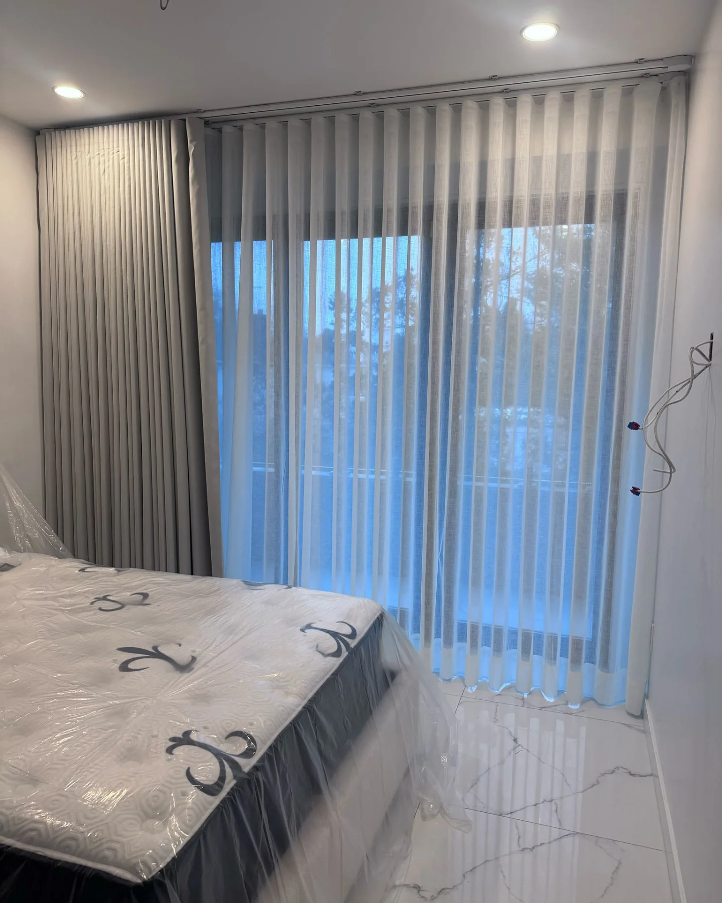 Cortinas tradicionales en velo instaladas en un dormitorio en Nueva York